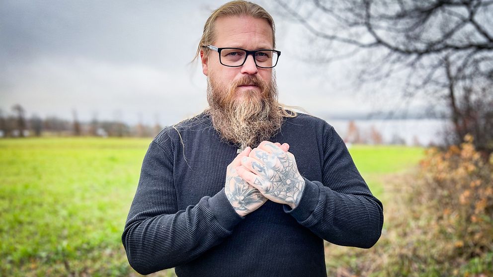 En man med långt skägg och tatuerade händer har drabbats av vibrationsskador som betongarbetare