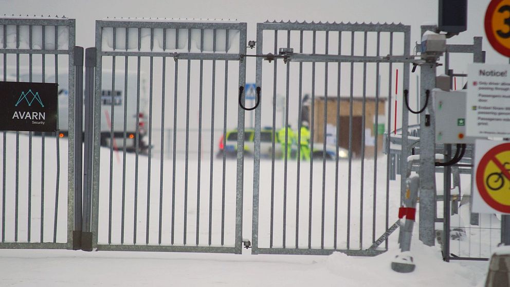 Stängsel utanför batterfabriken, polisbil syns i bakgrunden