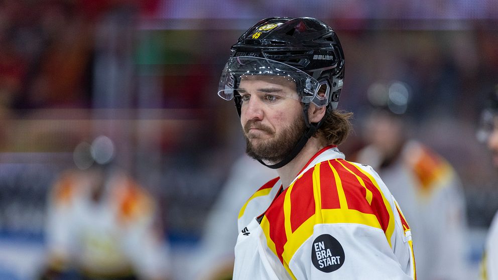 Ishockeyspelare i vit tröja med rödgula ränder och nummer 45 på isen under match.