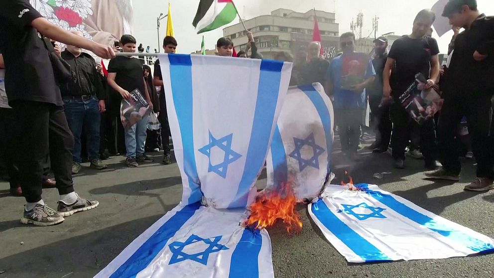 En israelisk flagga eldas upp i protester.