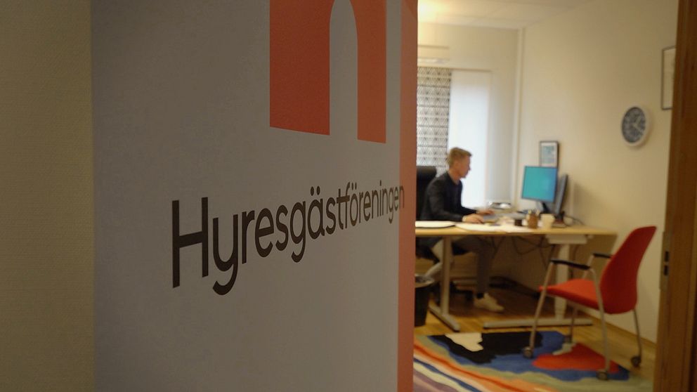 En bild på en skylt från Hyresgästföreningen och ett kontor i bakgrunden där Hasse Dahl sitter och arbetar i Östersund.