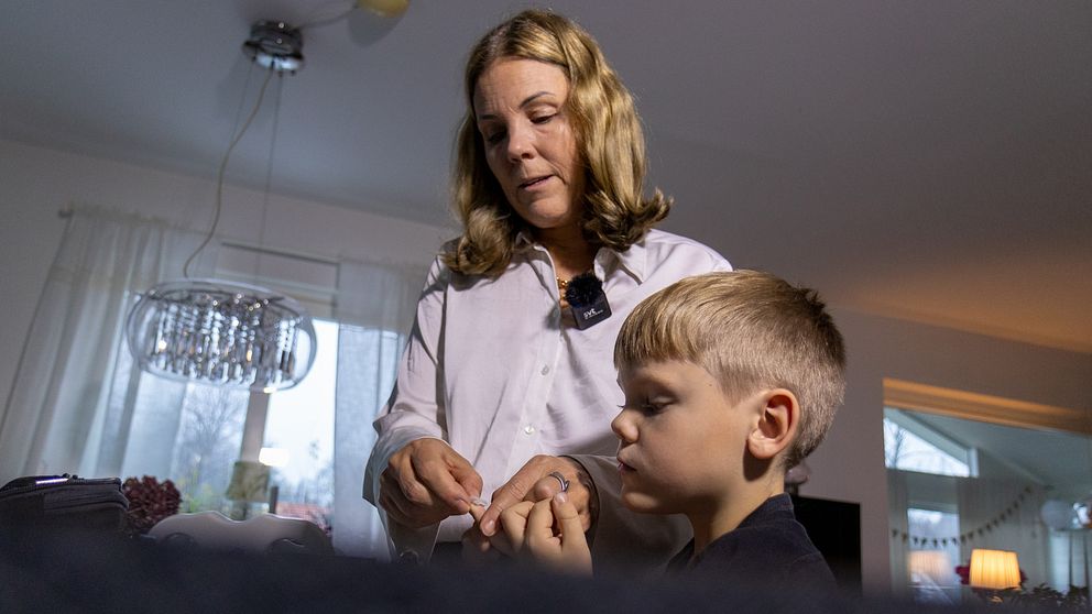 En kvinna tar blodprov på en sjuårig pojke.