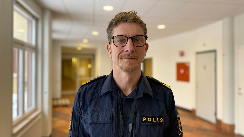 Johan Sangby, polis. Han har uniform på sig och står i en korridor.