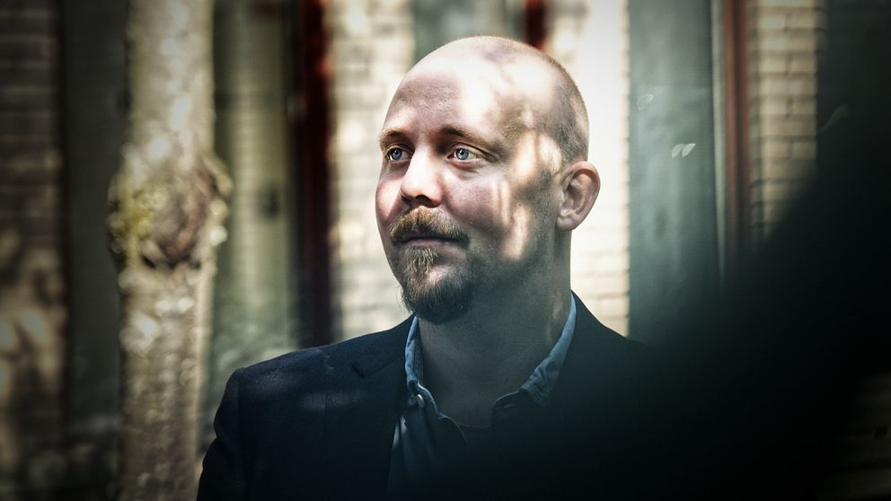 man utanför tegelbyggnad