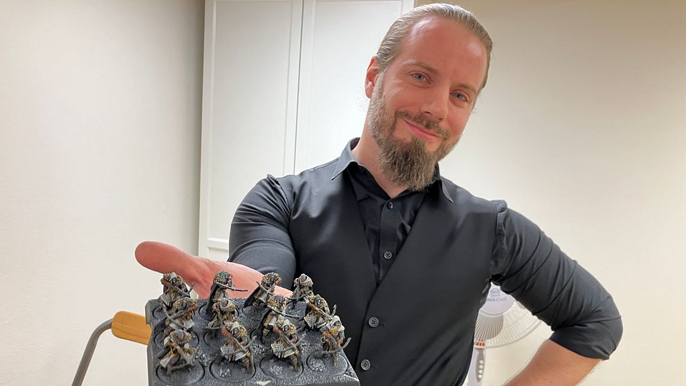 Västerås Wargamings ordförande visar upp ett bräde med spelfigurer.