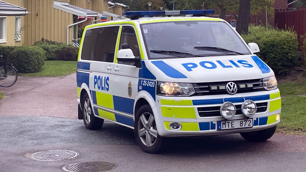 Polispiket framför gul träfastighet