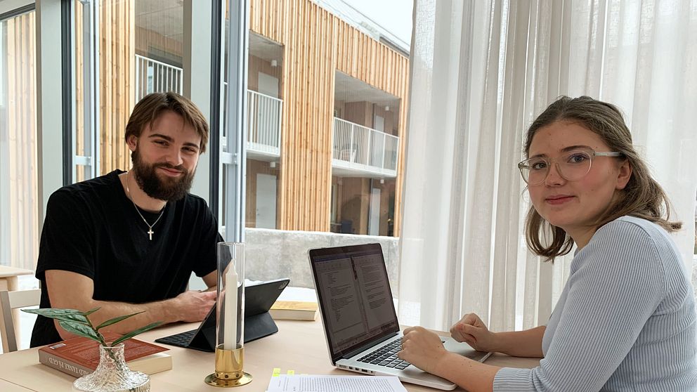 Edvin Hessel och Isabella Hessel sitter vid ett bord och pluggar. De sitter mittemot varandra och är vända mot kameran.