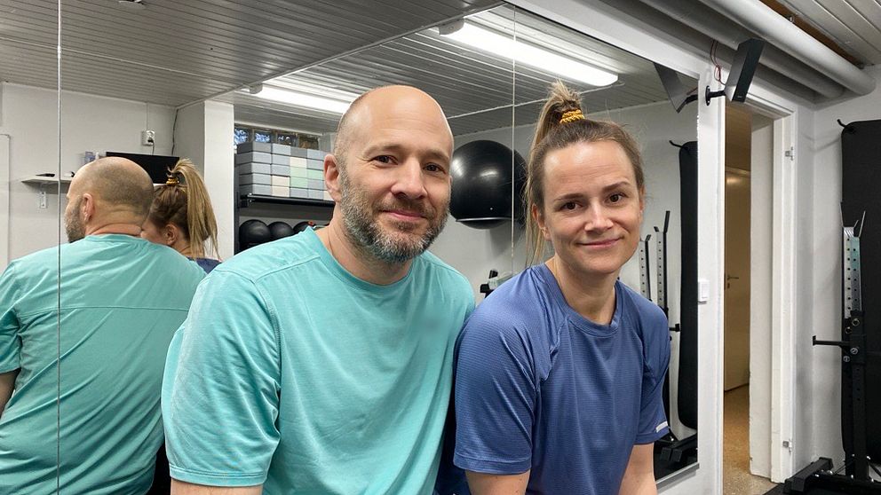 Maria och Fredrik Arvidsson sitter framför en spegel i sitt hemmagym i Eskilstuna.