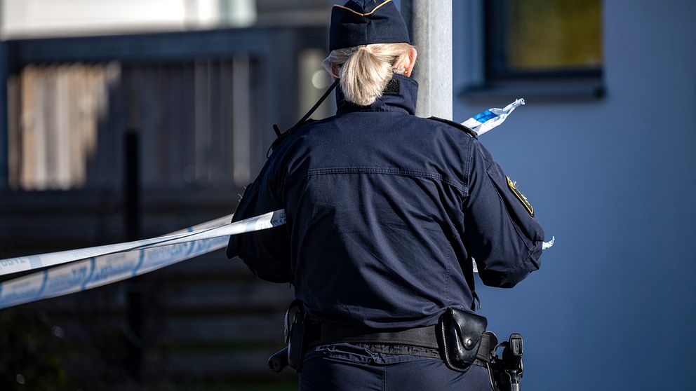 En bild på en polis som spärrar av ett område.