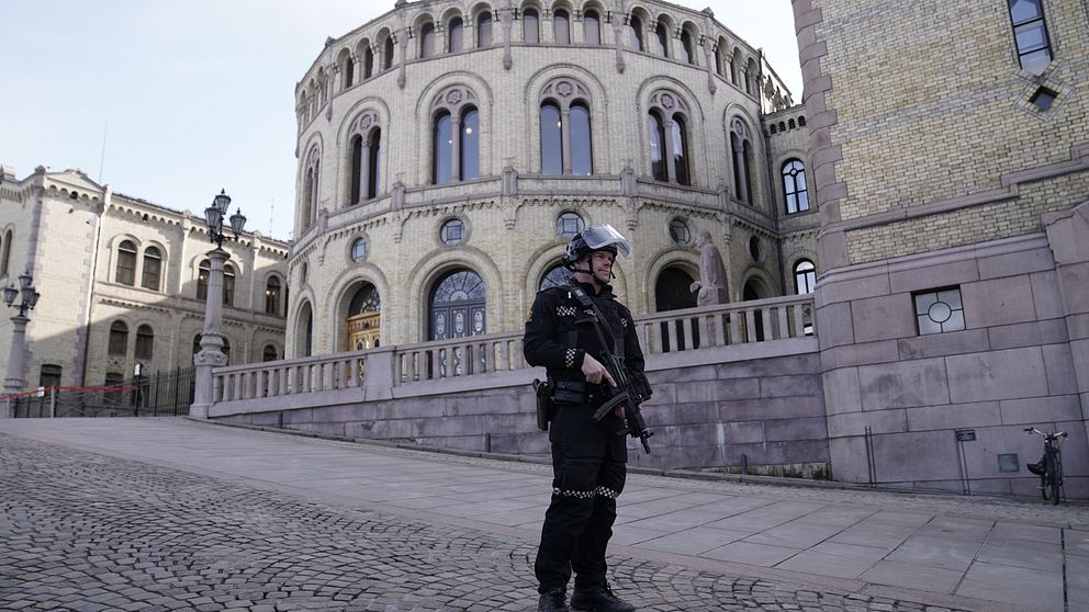 En beväpnad polis framför norska Stortinget