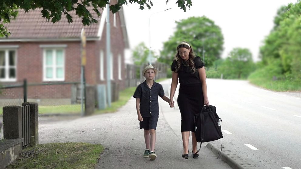 Eleven Wilhelm Dockenfelt, samt och mamma Emelie, går hand i hand förbi Oderljunga skola.