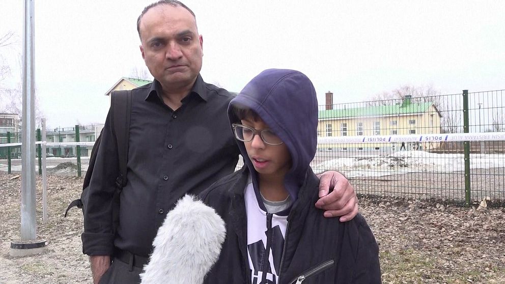 pojke står med sin pappa utanför skolan