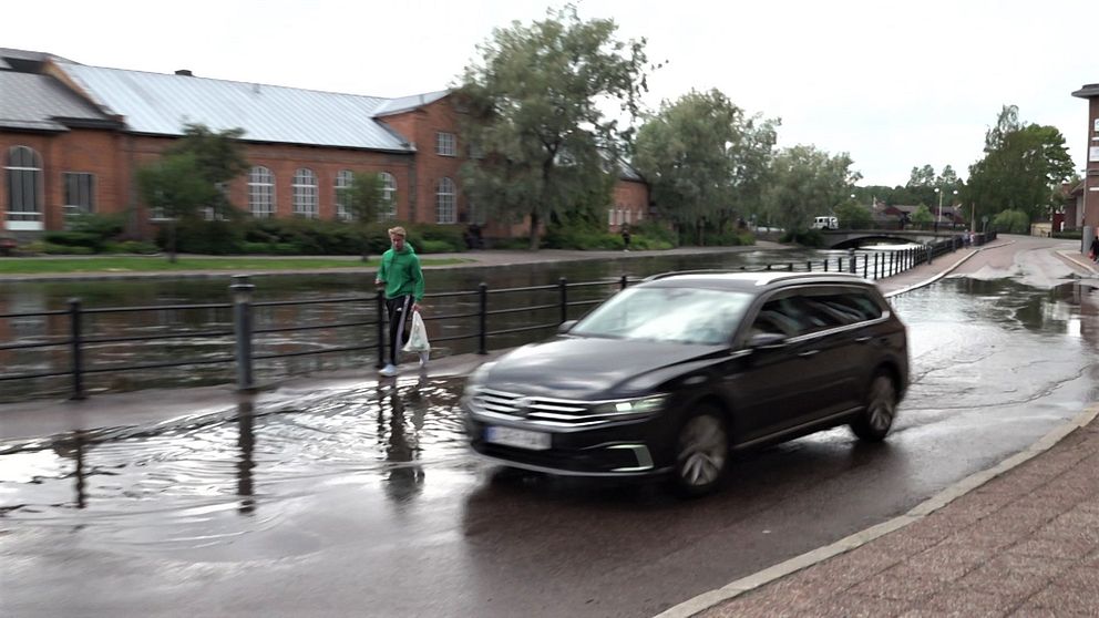 Bil som kör förbi översvämmad å i Falun