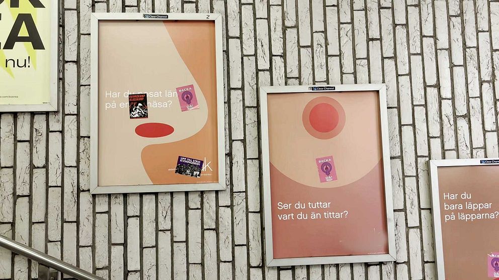 Två reklamaffischer med abstrakt design och klistermärken på tegelvägg inomhus.