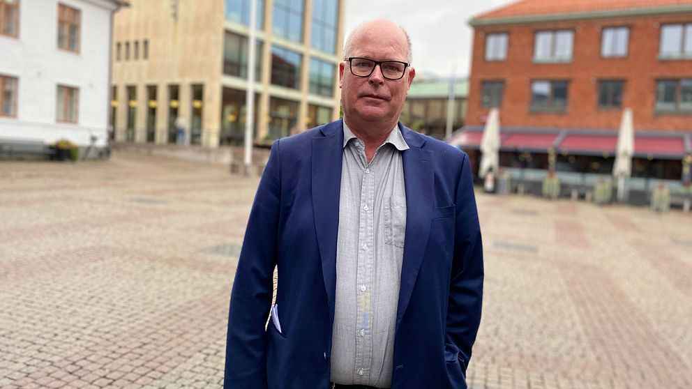Man iklädd en skjorta och mörkblå kavaj