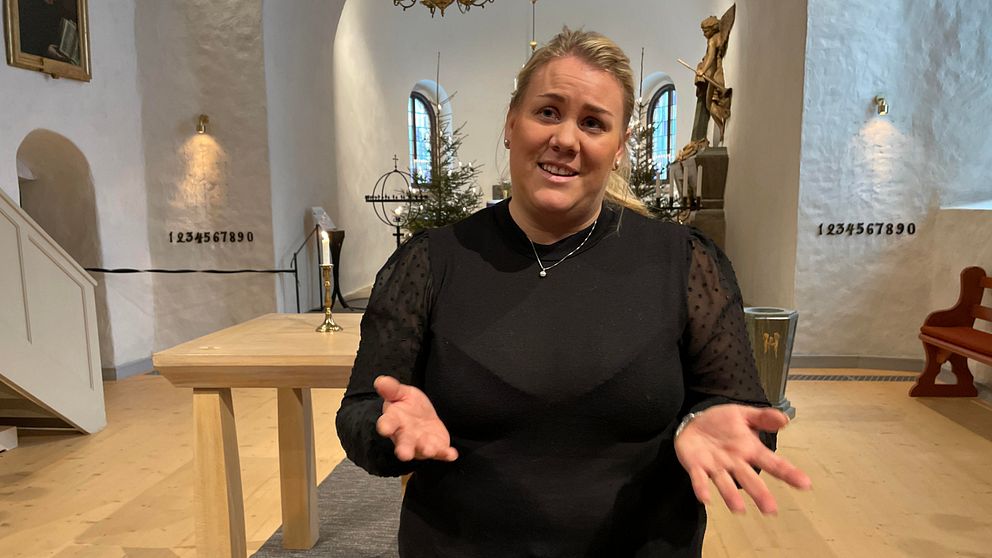 En kvinna längst fram i kyrkan.