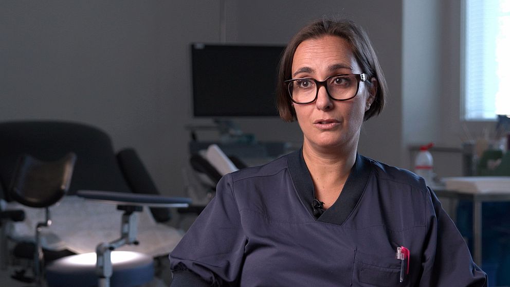 Emilia Rotstein, överläkare, l i sjukhusmiljö, svart uniform. Bakgrund med medicinsk utrustning.