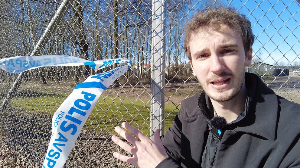 Man vid stängsel med polisavspärrningsband i bakgrunden.