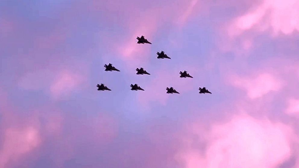 Nio stridsflygplan flyger i en julgransliknande formation mot en blårosa himmel i Norrbotten