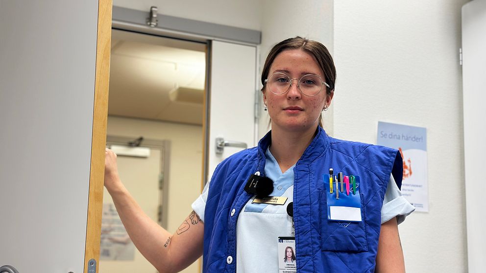 Sjuksköterskan Amanda Ljungberg står lutad mot en dörr på buk- och kärlkirurgiska avdelningen i Umeå