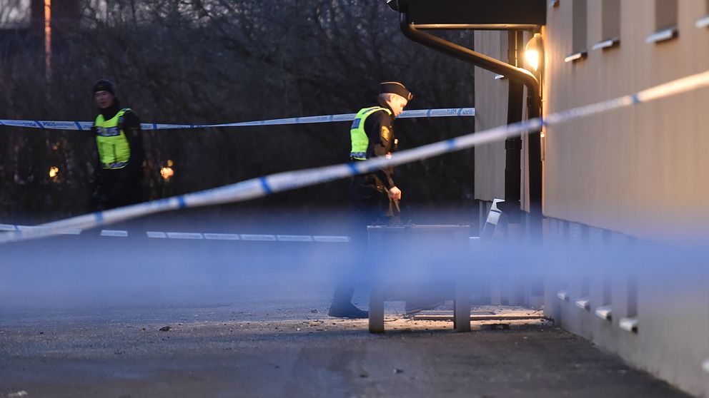 Polis i reflexvästar, avspärrningsband utanför trapphus vid lägenhetshus i Mjölby där explosion inträffat