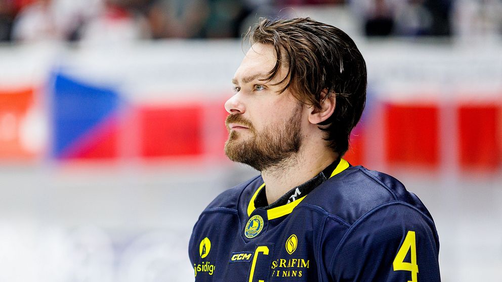 Ishockeyspelare i Tre Kronors blå-gula matchtröja med C och nummer 4 på bröstet.