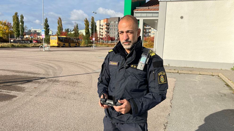 Polis med drönarkontroll i handen