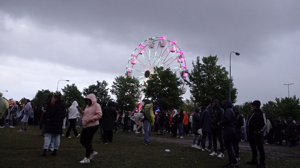besökare på Alivefestivlaen i BOrlänge, och ett parisehjul i bakgrunden