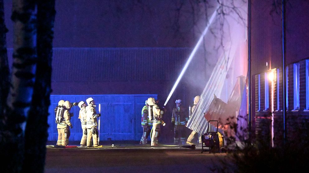 Brandmän står och spolar vatten på en lagerlokal i Marks kommun