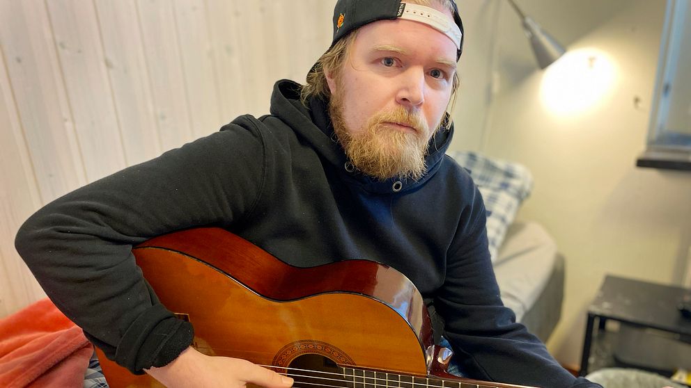 Johan Fridesjö bor på ett träningsboende i Luleå, på bilden spelar han gitarr.