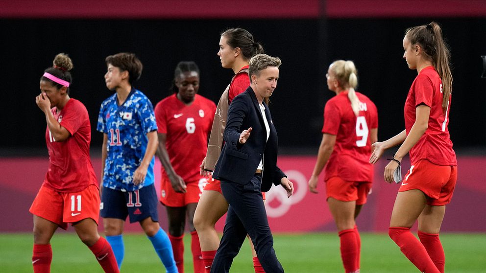 Förbundskaptenen Bev Priestman bland sina spelare vid OS i Tokyo där laget tog guld efter att ha besegrat Sverige efter straffar i finalen.