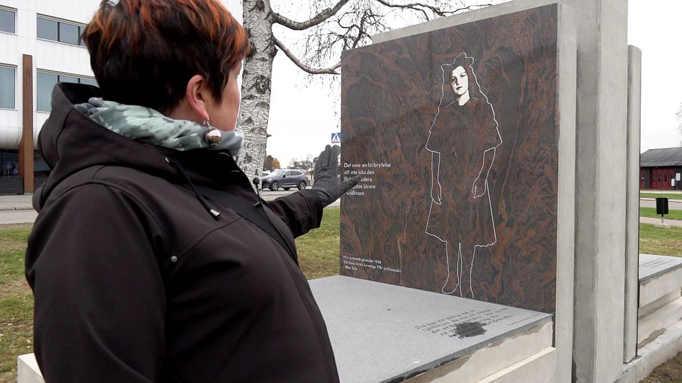 Mia Sörblom Groth pekar på monumentet över Agda Rössel.