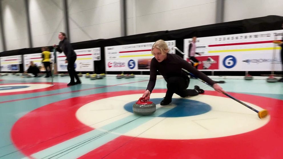 Curlingspelaren Emelie glider i väg längs isen.