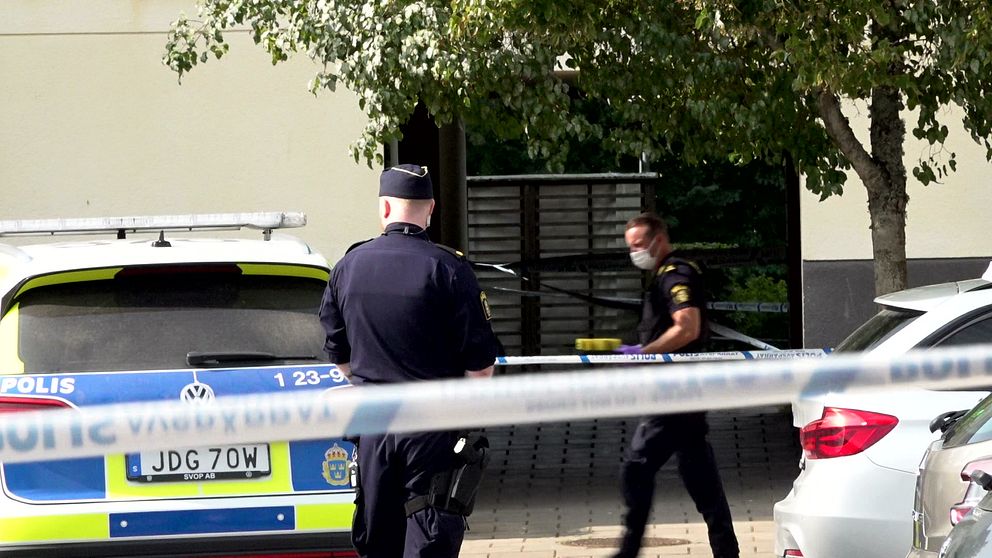 Avspärrningsband och två polisanställda.