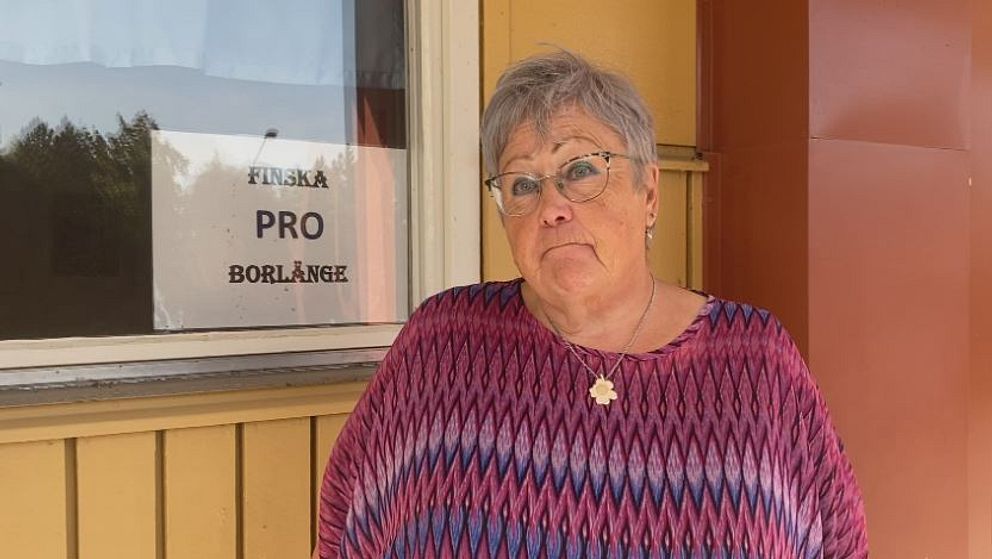 Leena Voutilainen SVT:n haastattelussa, taustalla Finska PRO Borlänge -kyltti. Kvinna framför skylt med texten Finska PRO Borlänge