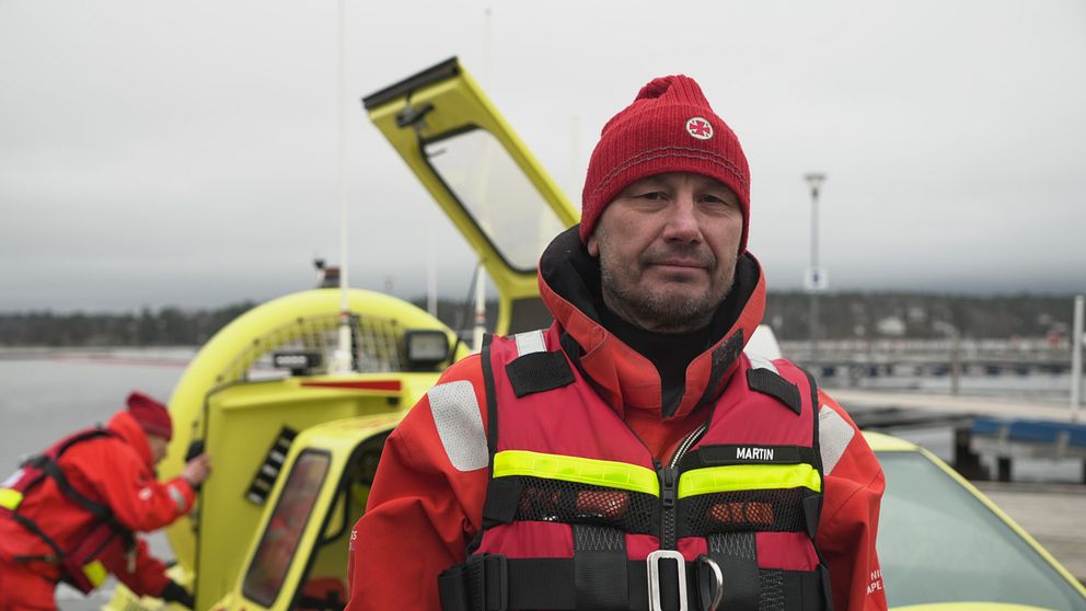 Martin Tengroth, frivillig sjöräddare står framför en svävare vid kaj.