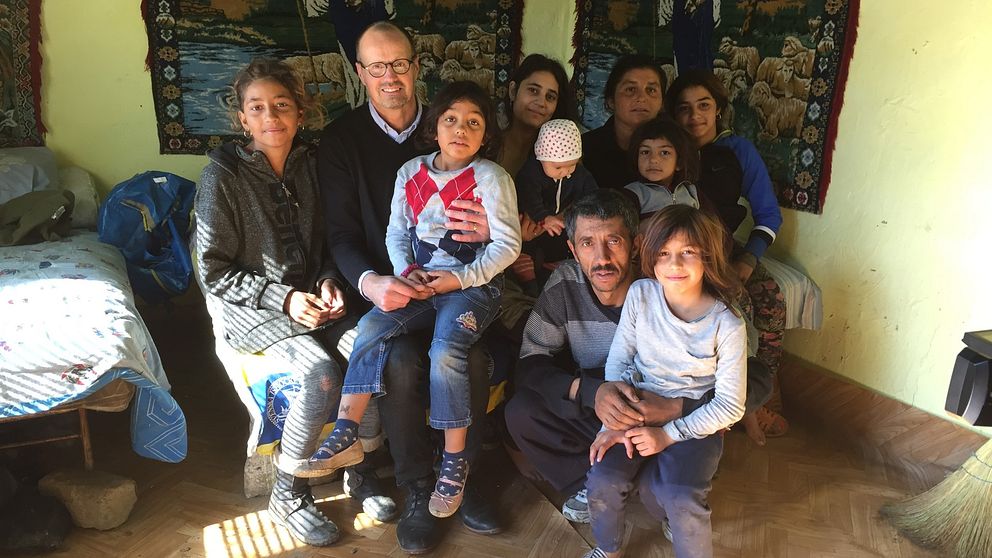 Irina Bujor i hemmet i Valea Seaca i Rumänien med delar av sin familj. I mitten sitter reporter Peter Nässén.