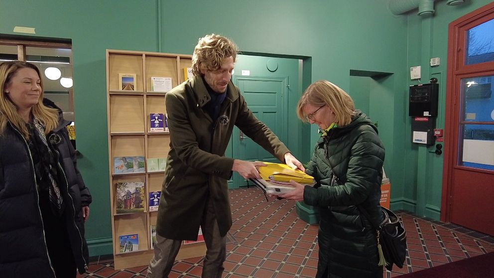 Madeleine Loostrand och Johan Uldall-Jörgensson lämnar över namnlistor till Lomma kommun för att få till en folkomröstning.