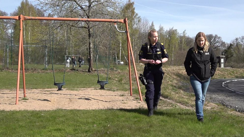 Polisen Maja Karlsson tillsammans med SVTs reporter promenerar på en skolgård.