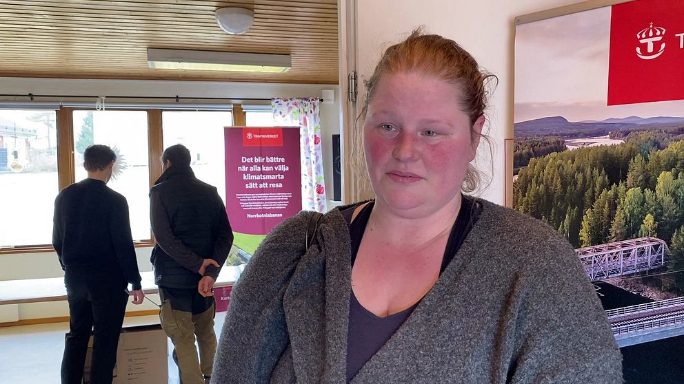 En rödhårig kvinna – fårbonden Johanna Larsson – intervjuas i rum med informationstavlor om Norrbotniabanan