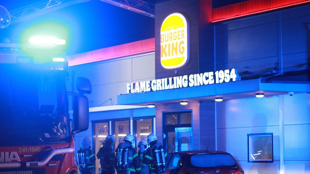 Brandmän utanför Burger King i Eskilstuna. På en skylt står det ”Flame grilling since 1954”-
