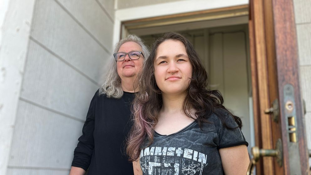 Mamma och dotter utanför sitt hus.