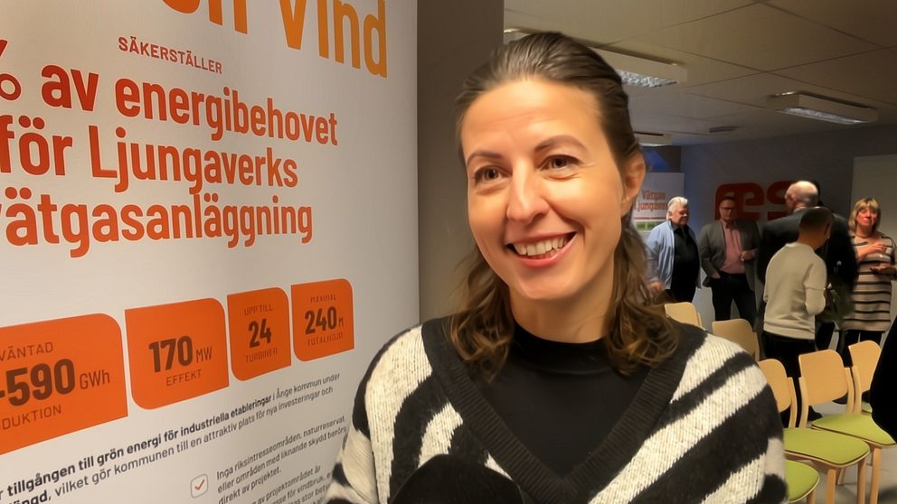 kvinna i randig tröja framför en affisch