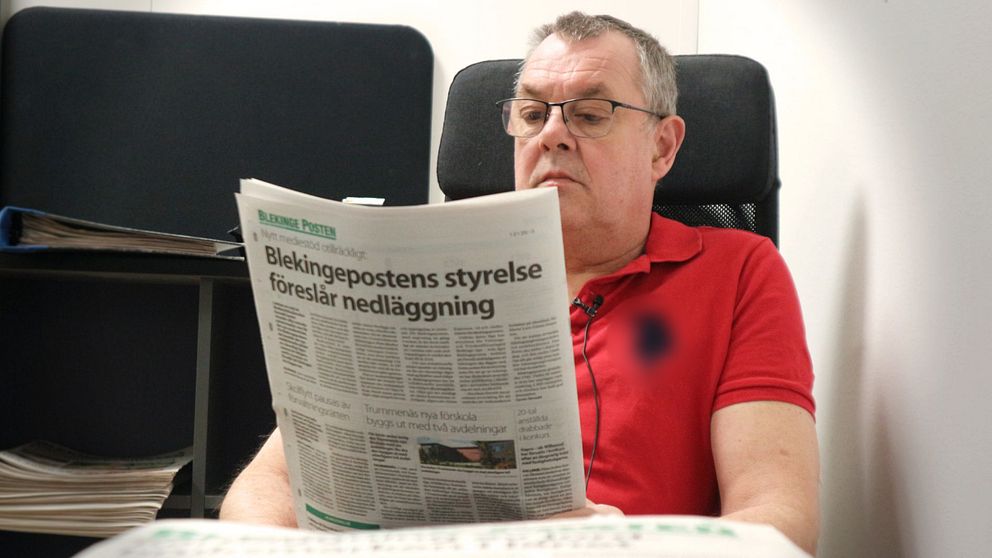 Blekingepostens chefredaktör Lars-Göran Enarsson sitter med en tidning.