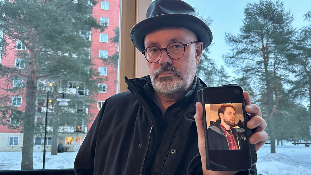 Anders Holmqvist visar en bild på sin son Mattias som dog i en arbetsplatsolycka i Umeå