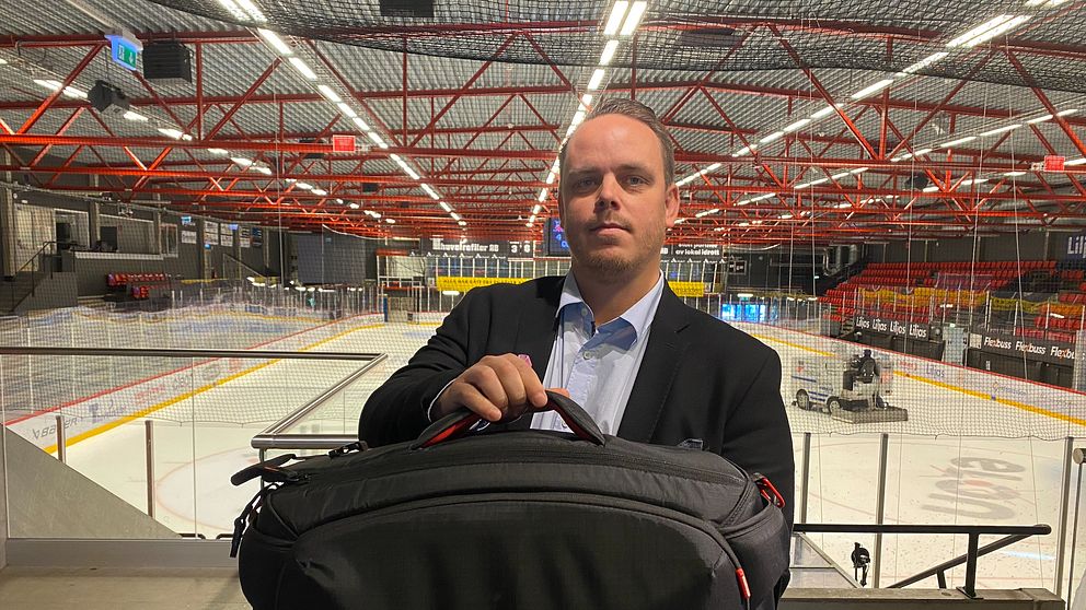 Kim Ahlqvist står framför hockeyplanen med en stor väska.
