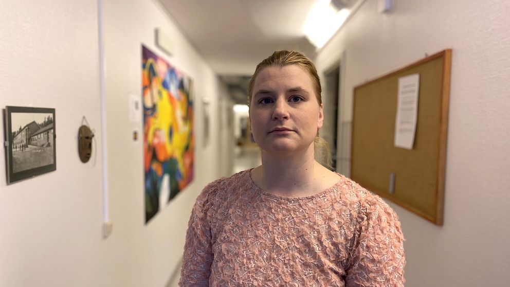 Malin Rimmö, rektor på Hansåkerskolan i Stugun står i en skolkorridor. Hon har blont uppsatt hår och är klädd i en rosa tröja med tygblommor fastsydda på.