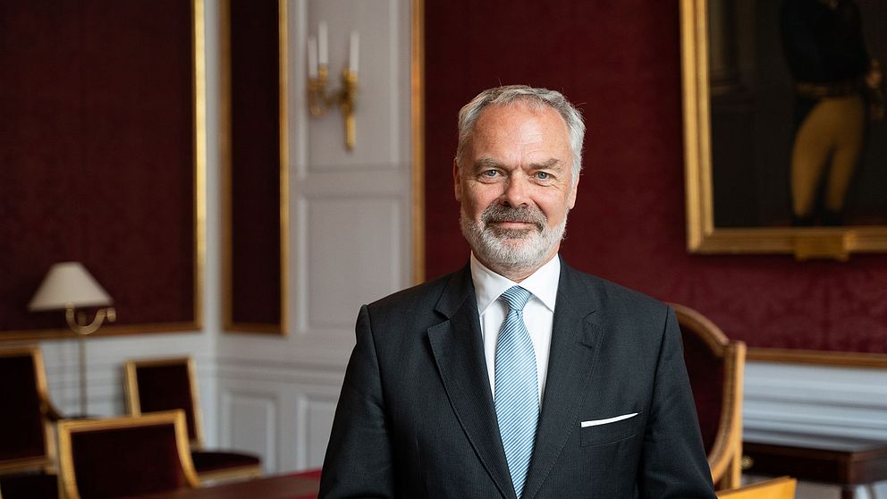 Jan Björklund, tidigare partiledare för Liberalerna, blir ny riksmarsalk vid hovet. Här fotad iklädd kostym i ett rum med röd tapet och inredning med gulddetaljer.
