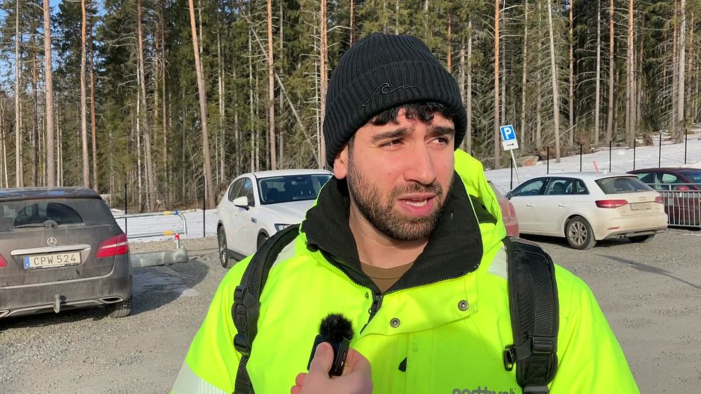 Ammar Soleman i neongul jacka vid en parkeringsplats vid northolt i Skellefteå.