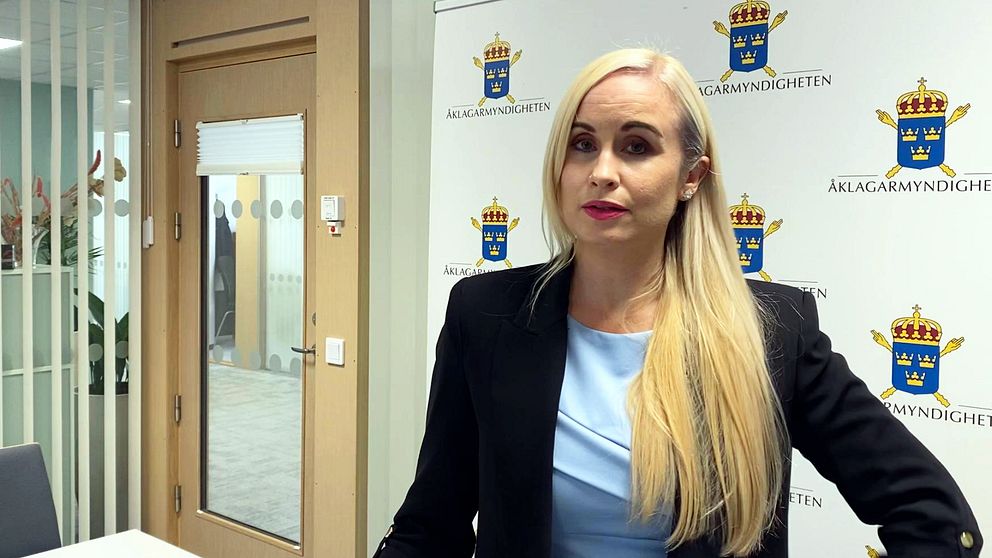 Åklagaren Karolina Lassbostår framför en vägg där det står ”åklagarmyndigheten”